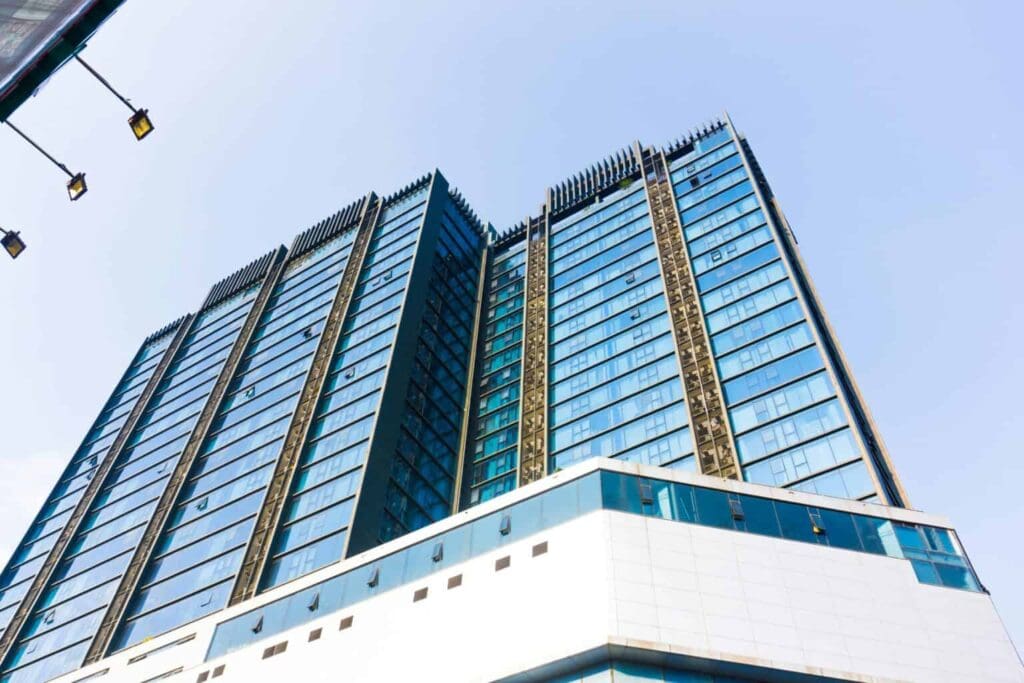 Modern glass office tower in Southern California with reflective blue windows under a clear sky.