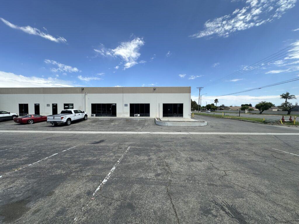 Street-facing industrial flex property with multiple glass storefronts, surface parking, and a loading ramp, photographed for KEYZ Commercial marketing.