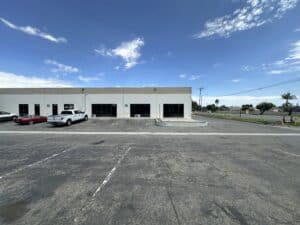 Street-facing industrial flex property with multiple glass storefronts, surface parking, and a loading ramp, photographed for KEYZ Commercial marketing.
