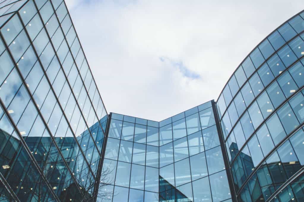 Modern glass office building exterior in Southern California showcasing contemporary commercial real estate architecture under a bright sky.